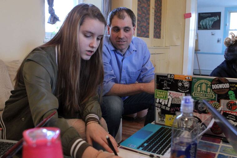 Joel Hammon (right), co-founder of Bucks Learning Cooperative, works with Faith Treacy in the cooperative's common room.