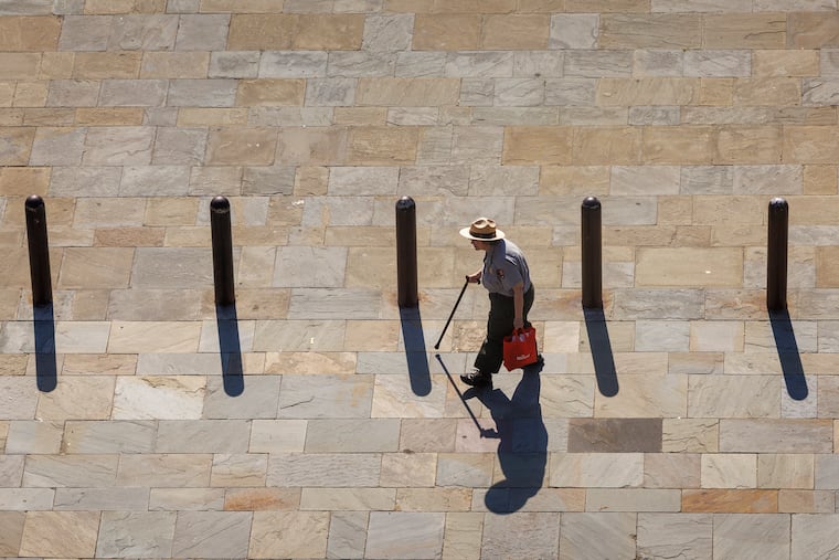 At Independence National Park, a ranger cast a shadow along South Sixth Street at Market Street in June.