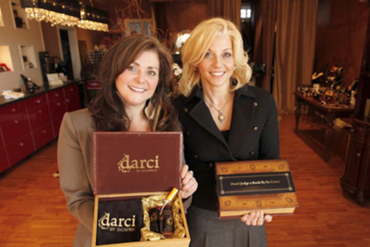 At Kiss and Makeup, Lisa Di Caprio (left) and Darci Henry display the cosmetic-brush cleaner that will be part of this year’s Oscar swag bag. (Laurence Kesterson / Staff Photographer)