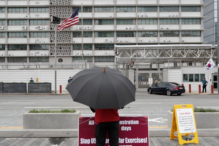 A man stands with a banner to oppose the joint military exercises between South Korea and the United States near the US Embassy in Seoul, South Korea, Sunday, Aug. 16, 2020. The countries will begin their annual joint military exercises this week, Seoul’s Joint Chiefs of Staff said Sunday. But a spreading coronavirus outbreak has apparently forced the allies to scale back an already low-key training program mainly involving computer-simulated war scenarios.