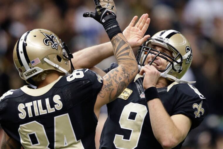 Saints quarterback Drew Brees (9) celebrates with wide receiver Kenny Stills (84) after a touchdown pass in the second half of an NFL football game in New Orleans, Sunday, Nov. 10, 2013. (Dave Martin/AP)
