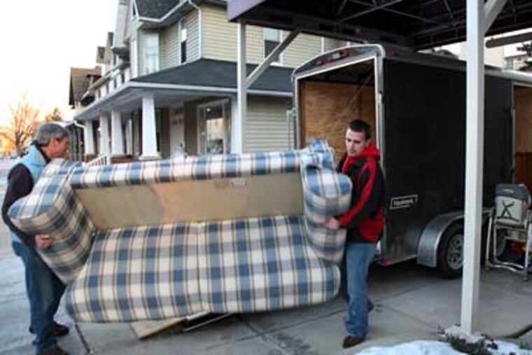 Allen Keller (left) and Nick Sikoutris load furniture into a trailer at New Community Christian Church in Coatesville. The furniture was donated to the victims of Coatesville's recent arson fires. (Laurence Kesterson / Staff Photographer)