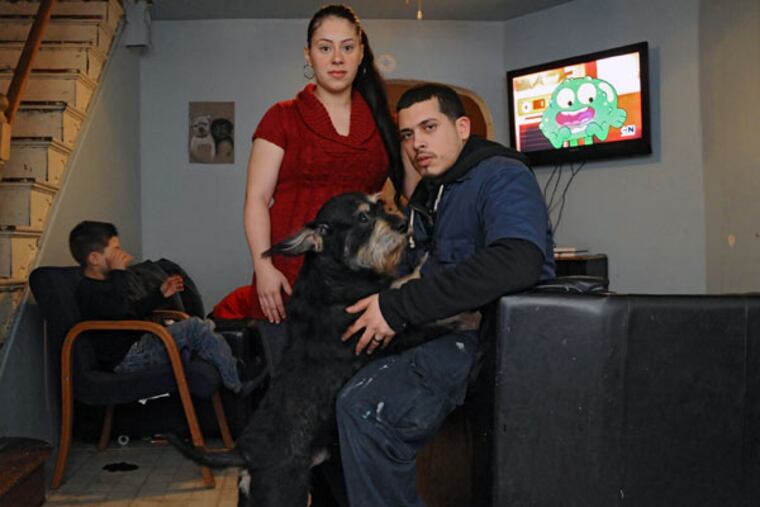 Nina Panagiotakis and Bienvenido Gutierrez, at home with their dog Oscar, one of two dogs in the house when police entered looking for a relative. (Clem Murray / Staff Photographer)