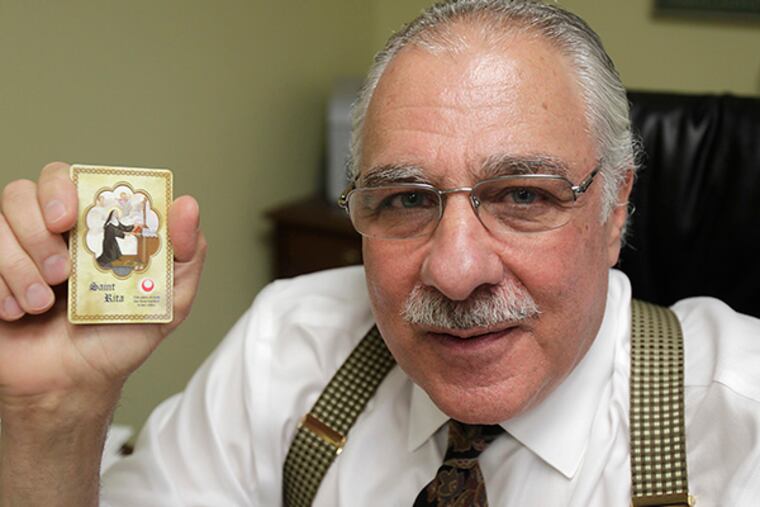 Donald Manno, a criminal defense attorney, successfully defended himself against criminal charges of racketeering and fraud. He is holding a Saint Rita's Holly Card, which he carried in his shirt pocket during the trial. ( AKIRA SUWA / Staff Photographer )