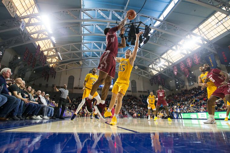 Nate Pierre-Louis, center, of Temple passes over Matey Juric, #15, of Drexel on Dec. 22, 2018 during the 2nd half at the Palestra. CHARLES FOX / Staff Photographer