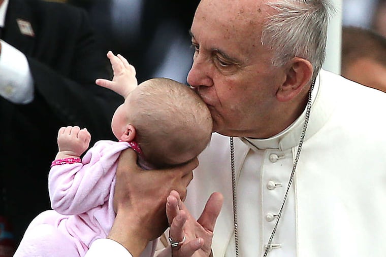 Pope Francis kisses a baby. "I feel blessed," the father of one chosen infant said. Story, A15.