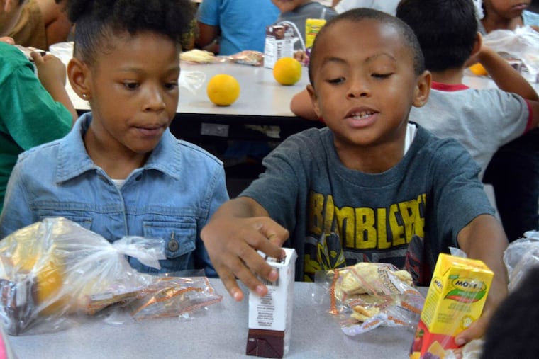 Anivea Allen (left), 6, and Zachary Cruz, 7, enjoy lunches provided by the Food Bank of South Jersey at the Camden Community Charter School. The program serves Burlington, Camden, Gloucester, and Salem Counties.