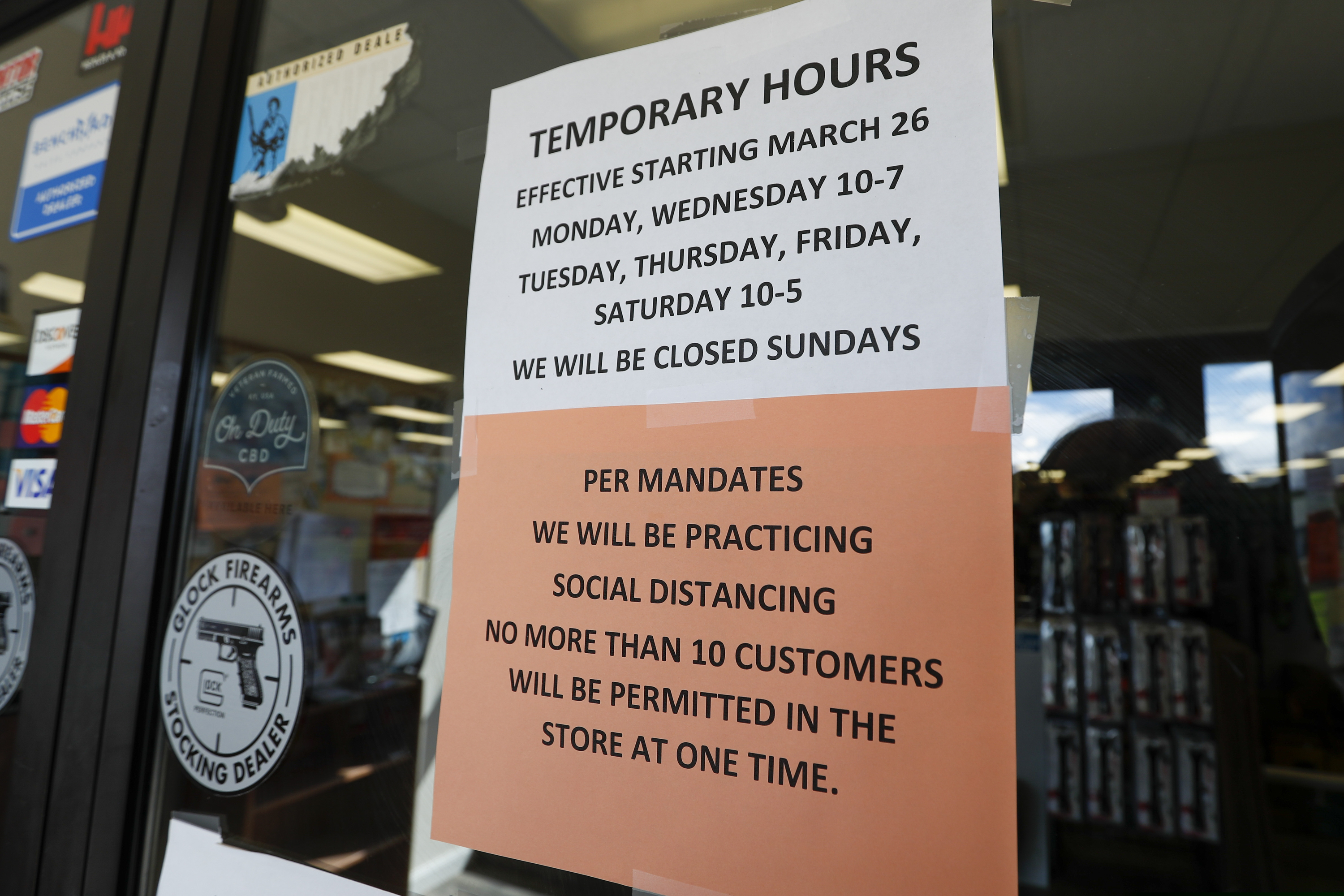 Signs on the front doors of Dukes Sport Shop show the hours and conditions to comply with conditions to reopen Wednesday, March 25, 2020, after being closed by last week's ordered shut down of nonessential businesses by Pennsylvania Gov. Tom Wolf, in New Castle, Pa.