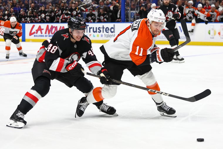 The Flyers' Travis Konecny is pressured by the Sabres' Tyson Kozak, left, during the second period of Buffalo's 5-3 victory on Thursday.
