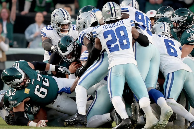 Former Eagles center Jason Kelce (62) leading the way as quarterback Jalen Hurts picks up a first down.