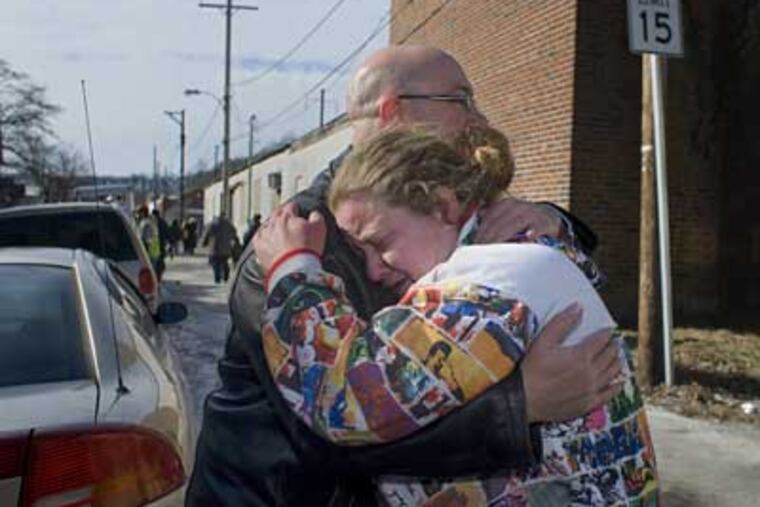 Neighbors John Wenger and Brandy Hickman embrace near their homes, which were destroyed by fire early Sunday morning in Coatesville. The fire destroyed 15 homes in the 300 block of Fleetwood Street. (Ed Hille / Staff Photographer)