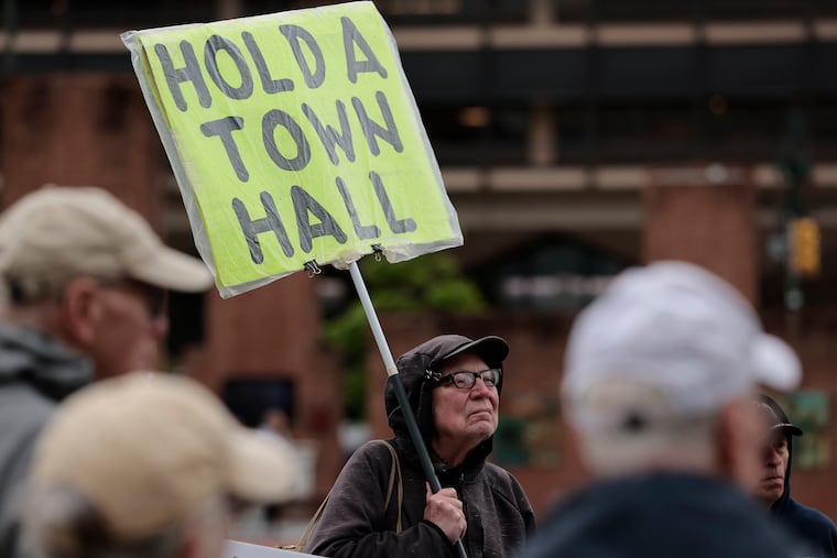 John Prenis of Philadelphia holds a sign at Independence Mall during Indivisible Philadelphia’s demonstration and march from Independence Mall to Senator John Fetterman's office at 2nd and Chestnut streets in Philadelphia on Friday, May 9.