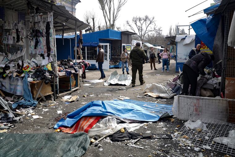 A lifeless body covered by plastic lies on the ground at a street market after the shelling that Russian officials in Donetsk said was conducted by Ukrainian forces, in Donetsk, in Russian-controlled Donetsk region, eastern Ukraine.