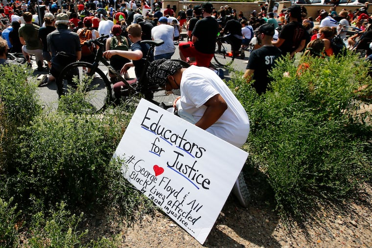 In this file photo, a demonstrator takes a knee in support of George Floyd during a march that ended at the Philadelphia School District Headquarters in early June.