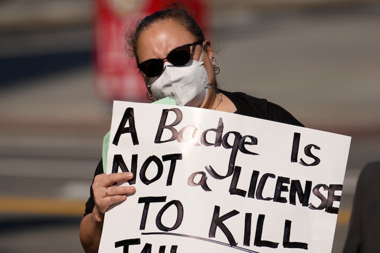 A woman holds a sign during a protest over the death of Tyre Nichols, who died after being beaten by Memphis, Tenn., police. Nationwide, police officers shot and killed a record 1,096 people last year.