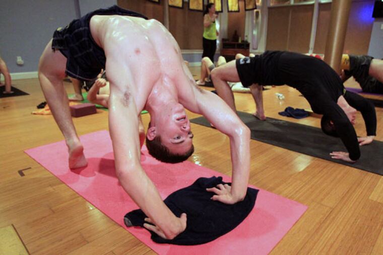 Members of the Collingswood High School wrestling team, including Michah Roth (left), take part in hot yoga at Anjali Power Yoga, in Westmont, on Jan. 6, 2015. The room is kept at about 95 degrees.