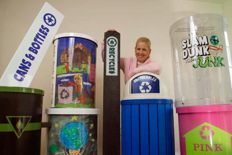 Bonnie Haas, president of Kettle Creek Corp., amid some of the recycling containers and signage her company makes.