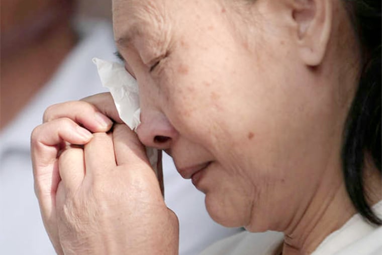Don Ly's widow, Saruong Thach , weeps during a vigil at the family's home.
