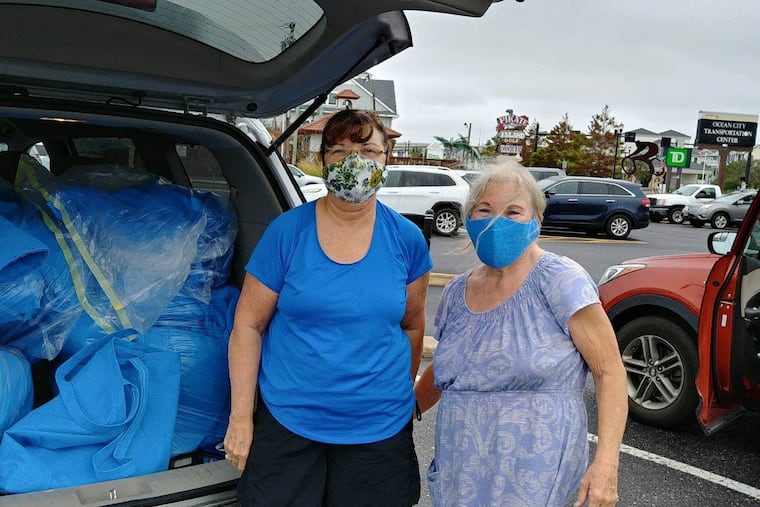 Ellie Tarnoviski (left) and Margaret Morris (right) with the many sterilization wraps collected by healthcare workers at Pennsylvania Hospital. Morris uses them to make masks and other supplies to help homeless veterans and children and others in need.
