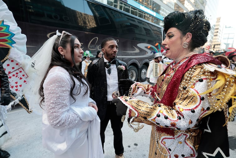 Julianna Bonilla (left) and Stanley Wells go over wedding service details before being married by Hegeman String Band captain Kelliann Gallagher (right) during the 2026 Mummers Parade in Philadelphia on Thursday, Jan. 1, 2026.