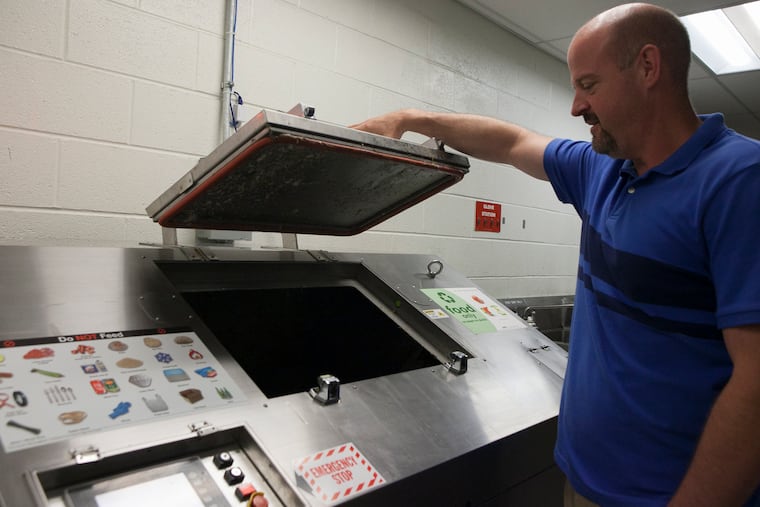 Michael Juhas, Temple's Director of Housekeeping looks into the food digestor in the basement of Morgan Dining Hall. Temple's Dining Services facilities Morgan Hall, Louis J. Esposito Dining Center, and the Howard Gittis Student Center reduce their landfill waste by utilizing food digestors that employ microorganisms to break down food waste made in the preparation process.