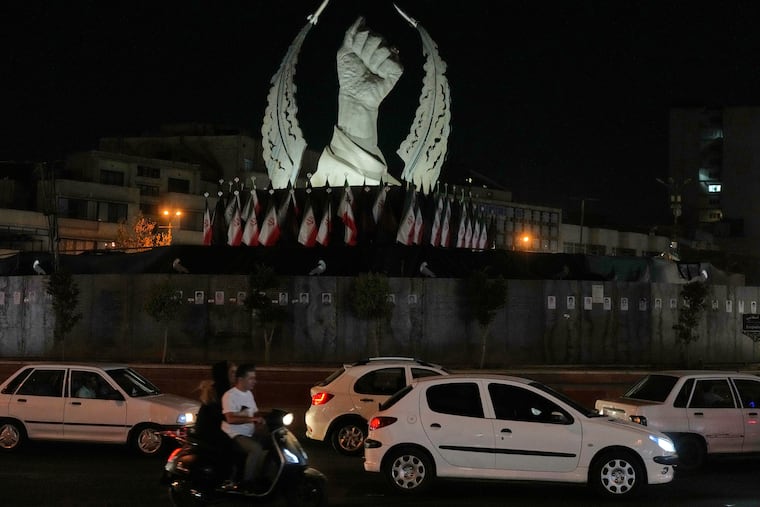 Vehicles drive past a monument depicting the clenched fist of the late Iranian Supreme Leader Ayatollah Ali Khamenei, who was killed in the U.S. and Israel strike on Feb. 28, in Islamic Revolution Square in Tehran, Sunday, July 19, 2026.