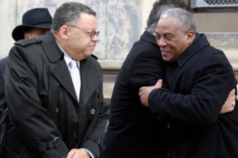 Police Commissioner-designate Charles Ramsey (left) stands by as Commissioner Sylvester Johnson (right) embraces former city solicitor Jonathan Saidel at a plaque dedication yesterday for Officers James Duffin & John Reid, who died after a 1973 accident.