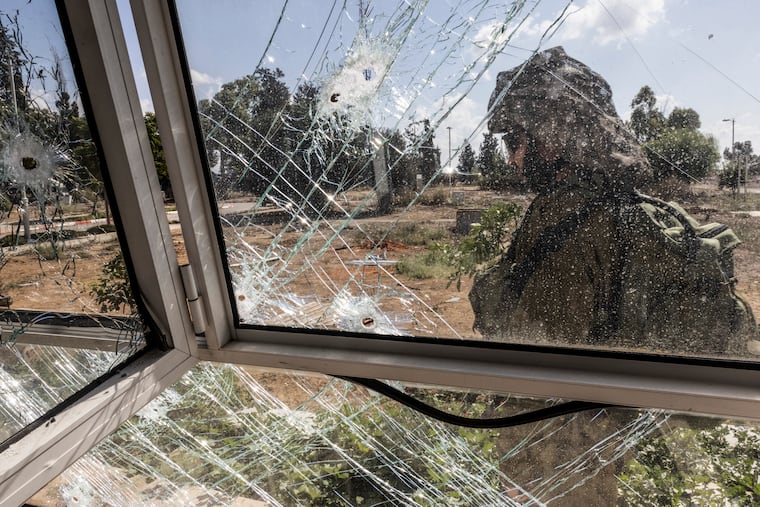 An Israeli soldier passes a family's home riddled with bullet holes in Kibbutz Kissufim, Israel, on Oct. 18. Hamas militants attacked the kibbutz on Oct. 7.