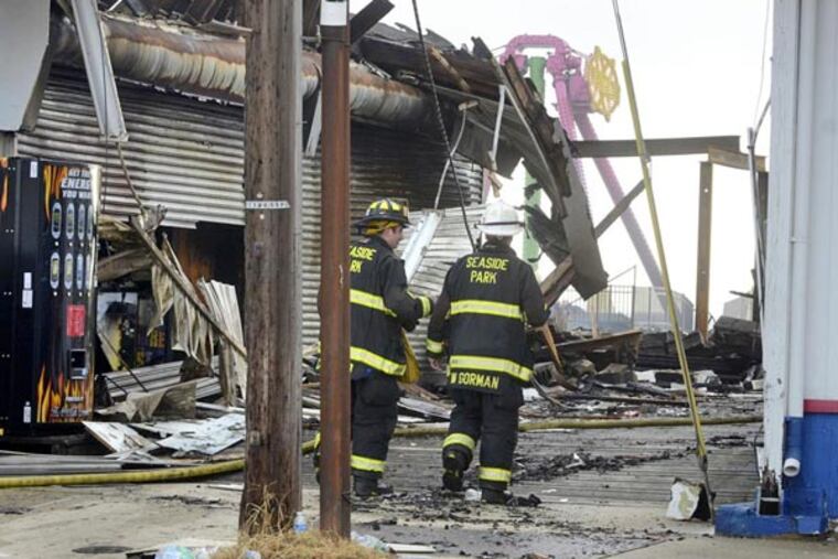 Firefighters clean up in Seaside Park early morning Sept. 13, 2013, after working a fire on the boardwalk all night. (TOM GRALISH / Staff Photographer)