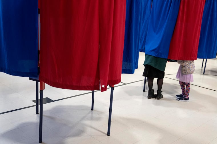 Kara Simard, left, votes with her daughter, Violet, 5, in the New Hampshire presidential primary at a polling site in Manchester, N.H., Tuesday, Jan. 23, 2024.