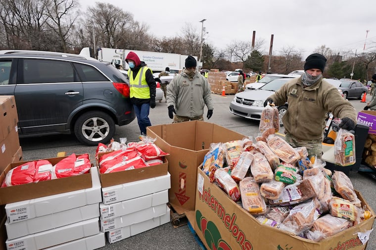 Sgt. Kevin Fowler organizes food at a food bank distribution by the Greater Cleveland Food Bank, Thursday, Jan. 7, 2021, in Cleveland. Food banks across America say these economic conditions are pushing demand for their support higher, at a time when their labor and delivery costs are climbing and donations are decreasing. The problem has grown to the point that President Joe Biden called for a Conference on Hunger, Nutrition and Health in September, the first since 1969.