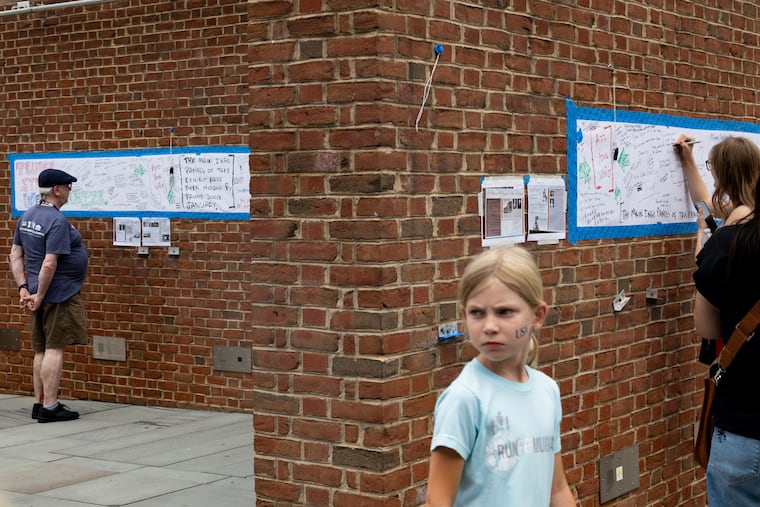 Visitors read and write on the unofficial signage at the President’s House in June. A unanimous appeals court panel ruled the City of Philadelphia lacks authority to control exhibit text.