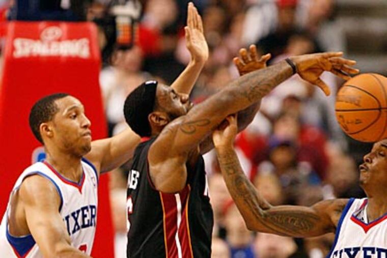 Evan Turner, left, and Lou Williams force a turnover by LeBron James during the fourth quarter. (David Maialetti/Staff Photographer)