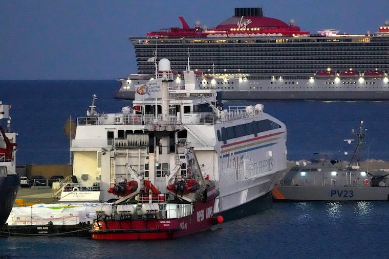 Aid packages are seen near the docked ship belonging to the Open Arms aid group, center front, as it prepares to ferry some 200 tons of rice and flour directly to Gaza, at the port in Larnaca, Cyprus, on Monday, March 11, 2024.