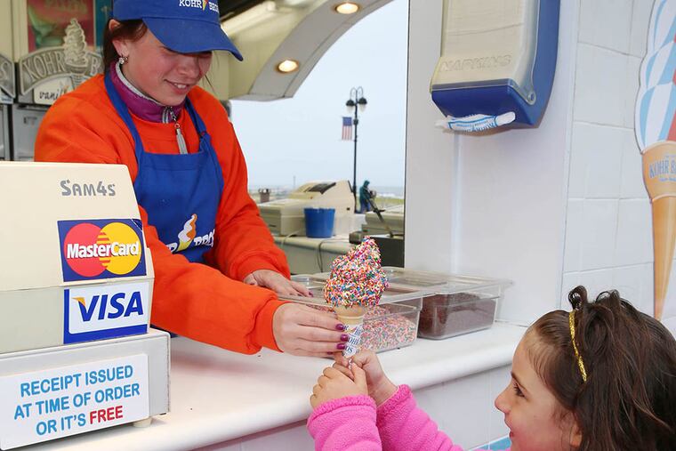 Anastasia Pegushina hands Jamie DiGiacomo a vanilla cone with sprinkles at Kohr Bros. (Tom Briglia/For the Inquirer)