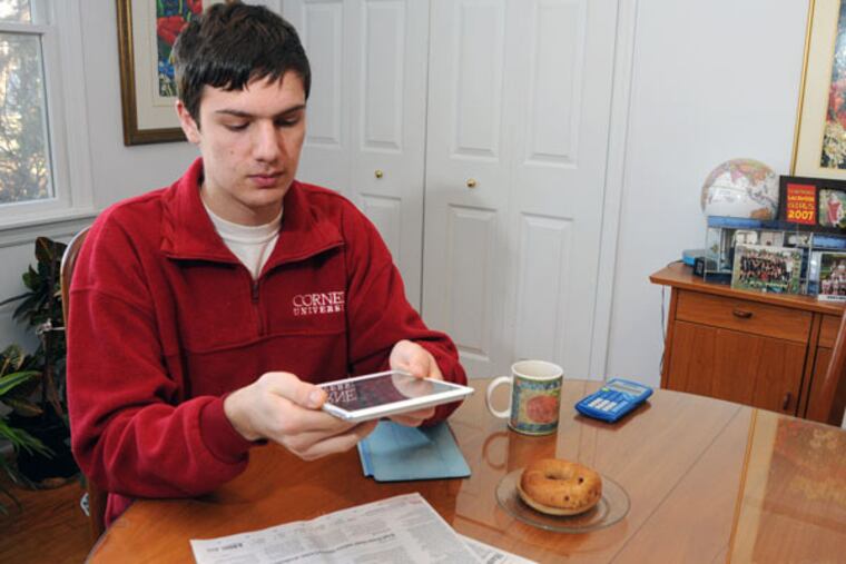 Brian Meersma scans a story from the page of a newspaper. The text will be converted to audio, allowing him to listen to the article.
