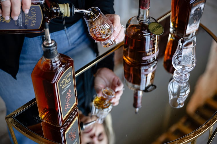 An employee pours a glass of Cinder & Smoke bourbon at the Bard Distillery in Graham, Ky., March 9, 2025. The distillery had hoped to expand exports to Canada, but plans were upended by the trade conflict.