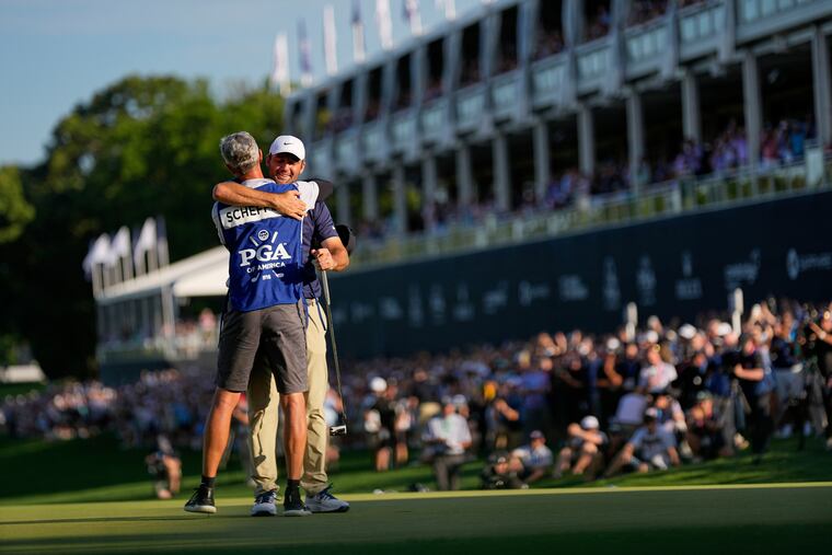 Scottie Scheffler hugs his caddie Ted Scott after winning the PGA Championship at the Quail Hollow Club on Sunday in Charlotte, N.C.