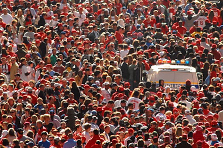 Phillies parade on S. Broad as police van tries to move through. (Peter Tobia / Staff Photographer)