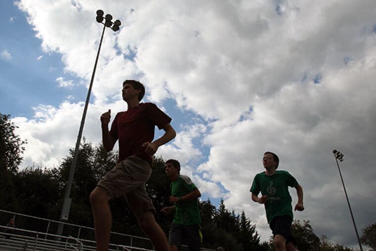 Runners make their way around the the track under the field lights on Sept 26, 2013. Residents in the New Hope-Solebury school district are expressing outrage over a recent board decision to end sports contests staged under stadium lights. They're also angry that the vote was not announced before the meeting, and say two of the board members live in a neighborhood affected by light pollution from the field. Runners make their way around the the track under the field lights on Sept 26, 2013. ( CHARLES FOX / Staff Photographer )