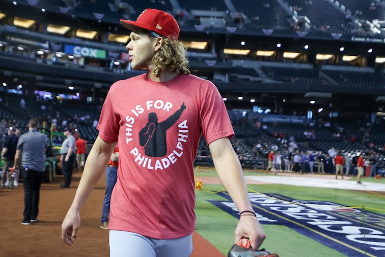 Philadelphia Phillies Alec Bohm greets fans in a T-shirt that reads, “This is for Philadelphia,” by local designer Hog Island Press, after completing warm-ups before Game 3 of the baseball NL Championship Series between the Arizona Diamondbacks and the Philadelphia Phillies on Thursday, Oct. 19, 2023, at Chase Field in Phoenix.