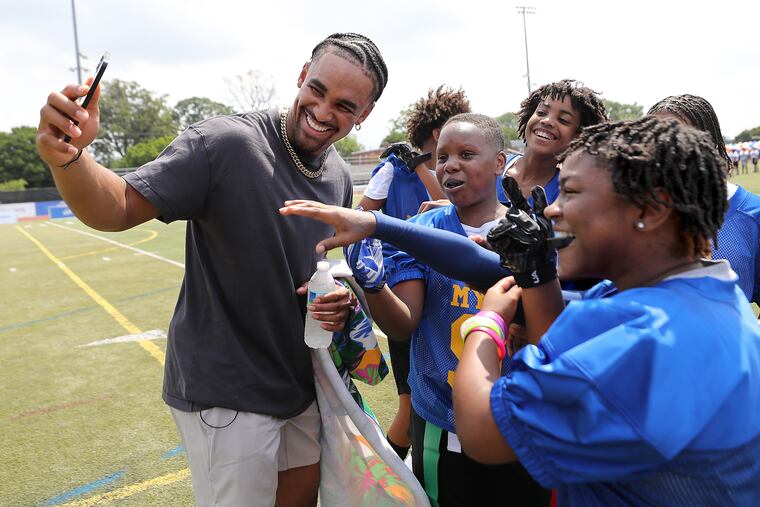 Philadelphia Eagles quarterback Jalen Hurts makes a video call to receiver A. J. Brown as he hangs with students from Middle Years Alternative school as he visits Benjamin L Johnston Memorial Stadium in Philadelphia, Pa. on Sunday, Aug. 28, 2022. Hurts and Kellogg’s Tony the Tiger announce a donation from Mission Tiger to the School District of Philadelphia. The donation will fund three new middle school Rookie Tackle program teams and start a new girls’ flag football program at six middle schools.