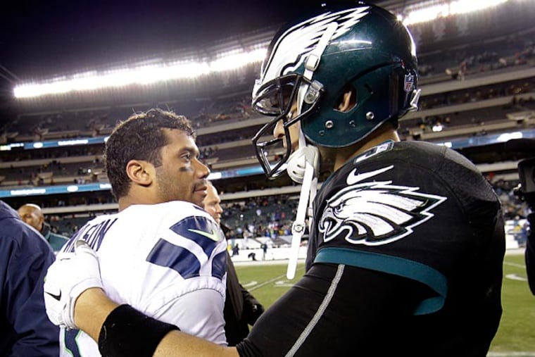 Seattle Seahawks' Russell Wilson, center and Philadelphia Eagles' Mark
Sanchez meet after an NFL football game, Sunday, Dec. 7, 2014, in
Philadelphia. Seattle won 24-14. (Michael Perez/AP)