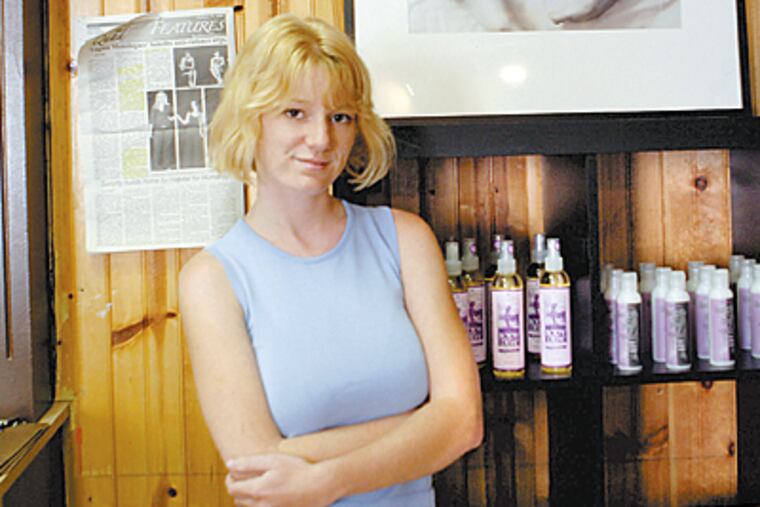 Jill McDevitt owns the Feminique Boutique in downtown West Chester. The shop, which a block from a Catholic school, has prompted a local cleric to file an appeal of the building permit. (Bonnie Weller/Inquirer)