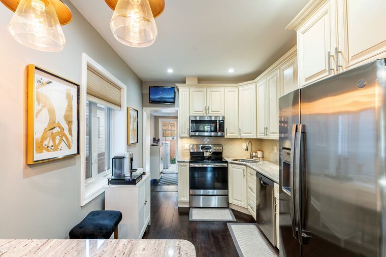 The kitchen of the Port Richmond house features stainless steel appliances and access to a back patio.