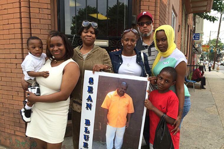 Margo Broaddus (center/fourth from left), the widow of Sean Broaddus, stands with relatives and supporters outside the hair salon where she works. (DANA DiFILIPPO / DAILY NEWS STAFF)