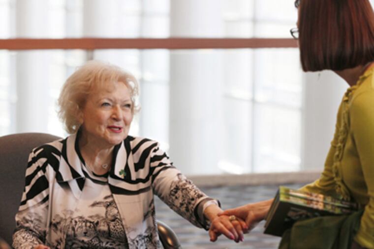 Betty White talks with Brandi Whitesell (right), a library director from the Free Library of Media-Upper Providence, after signing two copies of her book, "Betty and Friends: My Life at the Zoo." White closed out the Public Library Association convention at the Convention Center with a talk and book signing on Saturday. (Michael S. Wirtz / Staff Photographer)