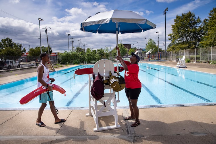 Lifeguard Jabrill David watches as Thelma Nesbitt sets up an umbrellas at Shepard Recreation Center in 2021.