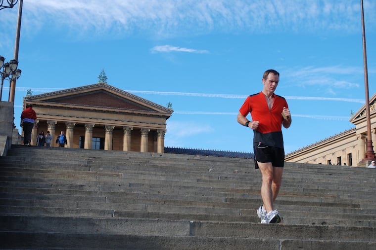 Mark Gibson runs down the Art Museum steps as part of a training run. Gibson, 64, and his daughter, Missy, are running 27.6 miles on the steps on Thursday to raise awareness for human trafficking.