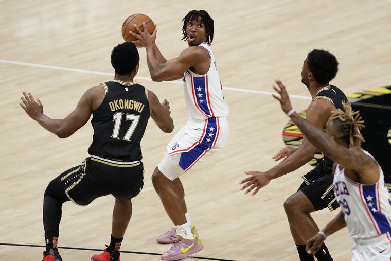 Sixers guard Tyrese Maxey looks to pass the basketball to teammate center Dwight Howard against Atlanta Hawks forward Onyeka Okongwu and guard Lou Williams in Game 6 of the NBA Eastern Conference playoff semifinals on Friday, June 18, 2021 in Atlanta.